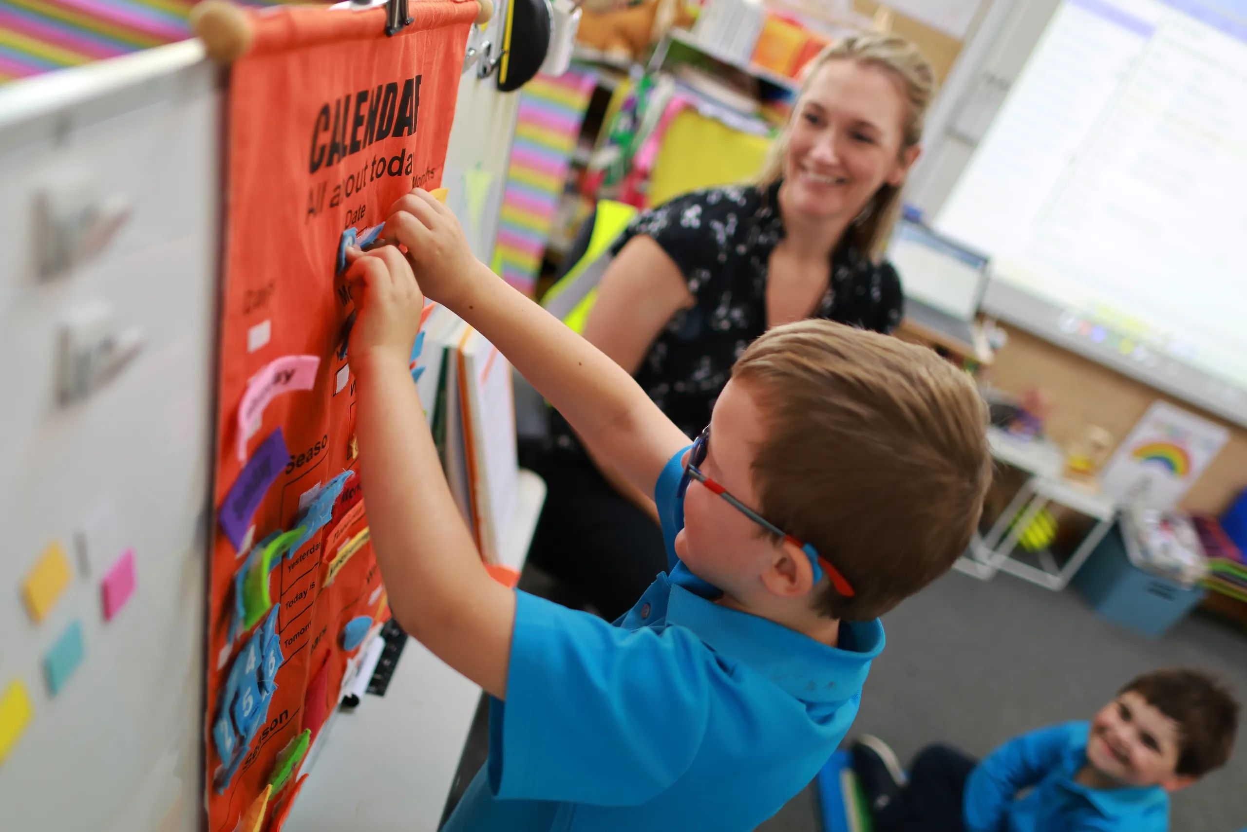 Prep students holds up the name of the day as the students work through their morning calendar routine.