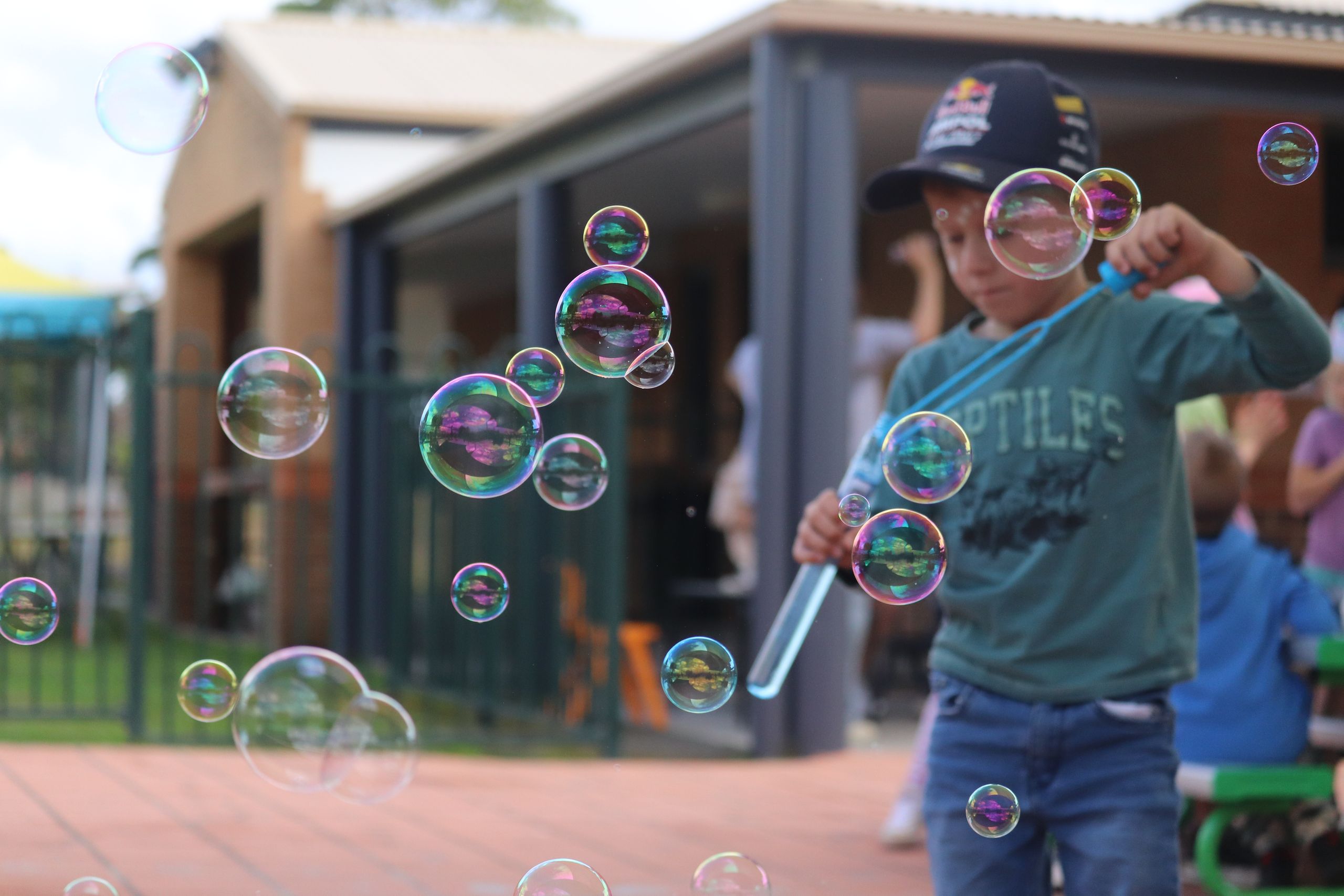 Student blowing bubbles during foundation day, bubbles are in focus while student is in soft focus.